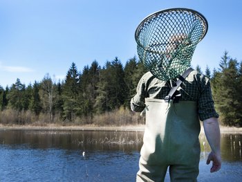 Fischer mit Casher am Fischteich