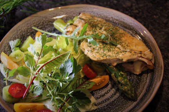 Die mit Schinken, Käse, Spargel und Kräuter gefüllten Hühnerschnitzerl mit Blattsalat der Saison servieren.
