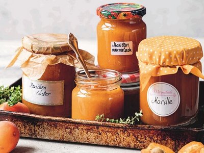 Marillenmarmelade und Marillenröster auf Tablett mit Marillen als Deko