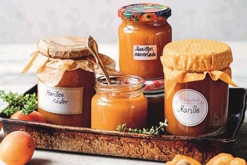 Marillenmarmelade und Marillenröster auf Tablett mit Marillen als Deko