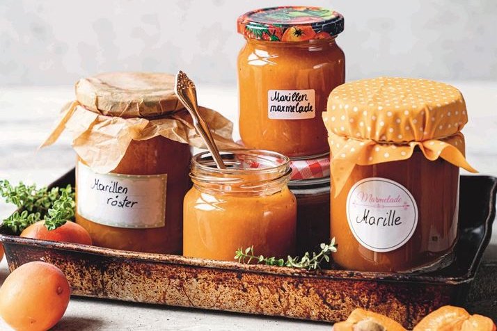 Marillenmarmelade und Marillenröster auf Tablett mit Marillen als Deko