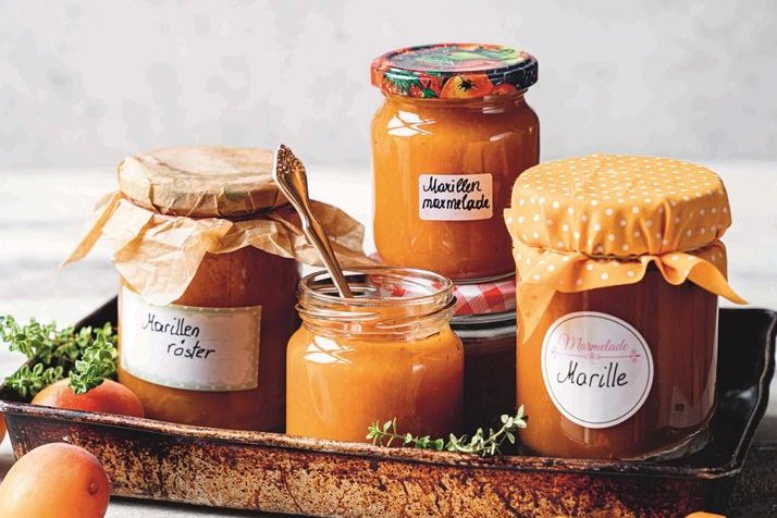 Marillenmarmelade und Marillenröster auf Tablett mit Marillen als Deko