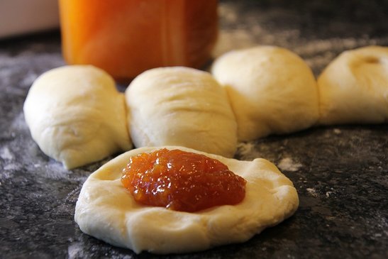 Mit einem Löffel Marmelade in die Mitte setzen.