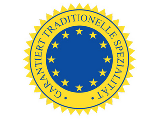 gelber Kreis mit blauer Mitte, in der Sterne dargestellt sind. Rund herum steht garantiert traditionelle Spezialität.