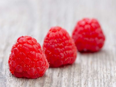 Himbeeren liegen auf einem Holztisch