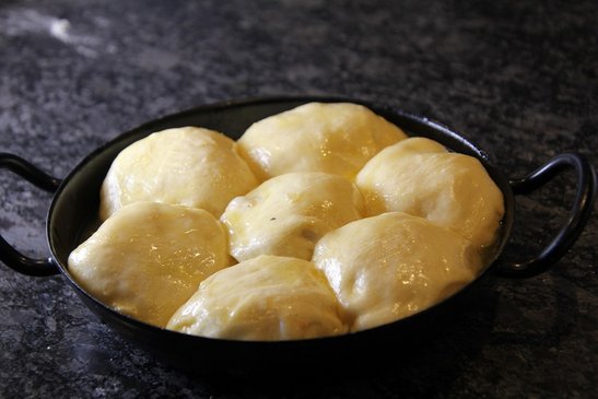 Buchteln mit dem Verschluss nach unten in eine befettete Auflaufform setzen.