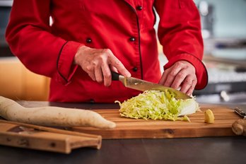 Seminarbäuerinnen schneidet Salat und Wurzelgemüse