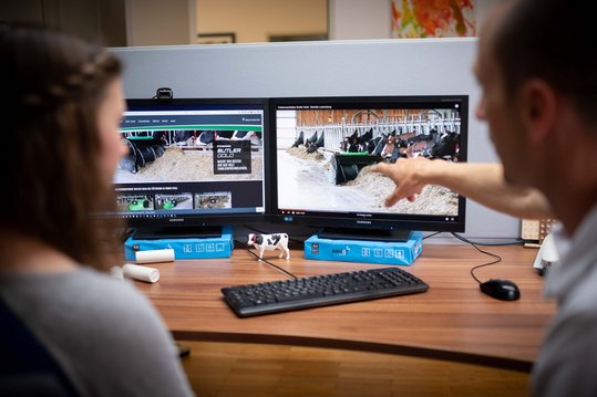 Zwei Personen sitzen vor Bildschirm und analysieren digitalisierte Landwirtschaft 