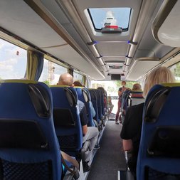 Personen sitzen im Bus bei Fahrt zu den Betrieben bei Afterwork am Bauernhof