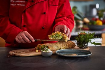 Köchin schneidet Strudel entzwei