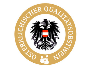In einem Kreis mit goldenem Rand steht mit weißer Schrift "Österreichischer Qualitätsobstwein", daneben sind Birne und Apfel abgebildet. In der weißen Mitte ist der österreichische Adler platziert.