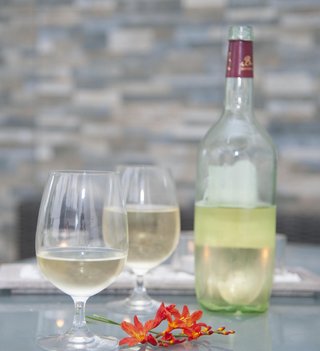 Zwei Gläser mit Most und Mostflasche im Hintergrund