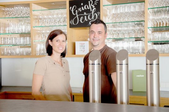 Heurigenbetreiber Corinna und Jürgen Haslinger hinter ihrer modern gestalteten Ausschank mit viel Holz.