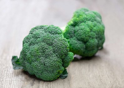 Brokkoliköpfe liegen auf einem Holztisch