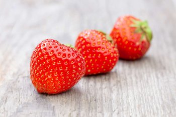 Erdbeeren liegen auf einem Holztisch