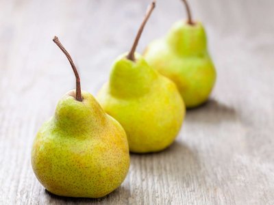 Drei Birnen liegen auf einem Holztisch