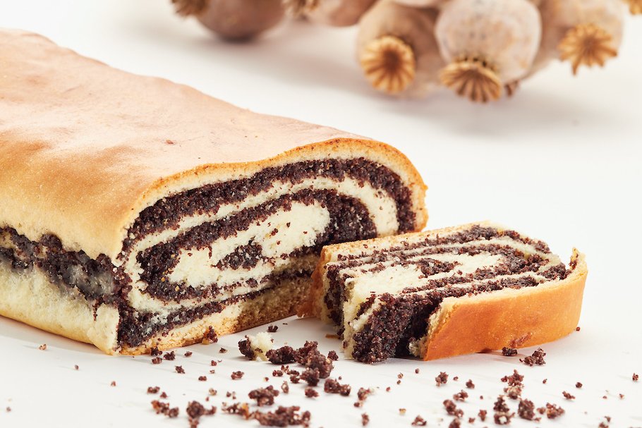 Strudel mit Graumohn angeschnitten dahinter Bund mit Graufmohn-Kapseln