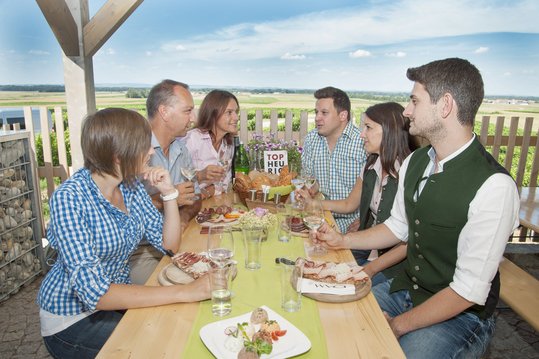 Gruppe Personen sitzt bei Top-Heurigen auf Terrasse bei Wein und Most und Brettljause ©Eva Lechner/LK Niederösterreich