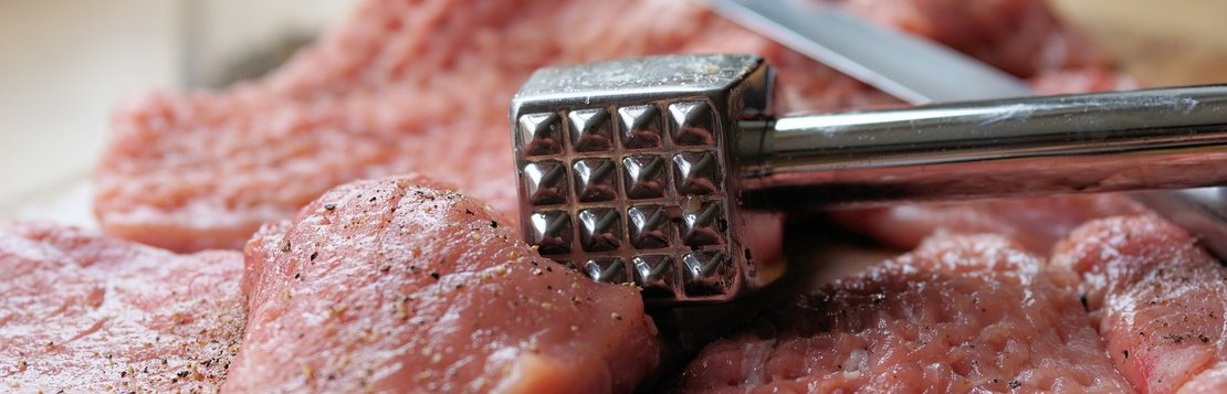 Schnitzelfleisch mit Fleischklopfer bearbeiten - das sorgt dafür, dass das Fleisch gleichmäßig zart und saftig ist und es sich beim Braten nicht zusammenzieht.