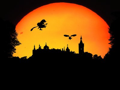 Hexe fliegt am orangefarbenen Himmel