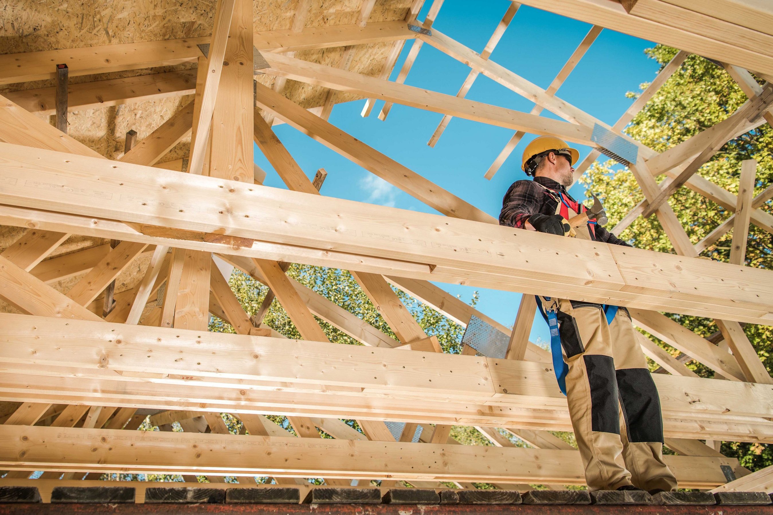 Arbeiter auf Balken beim Bau eines Holzhauses
