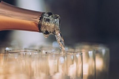 Mit einer Flasche Schaumwein werden Sektgläser gefüllt