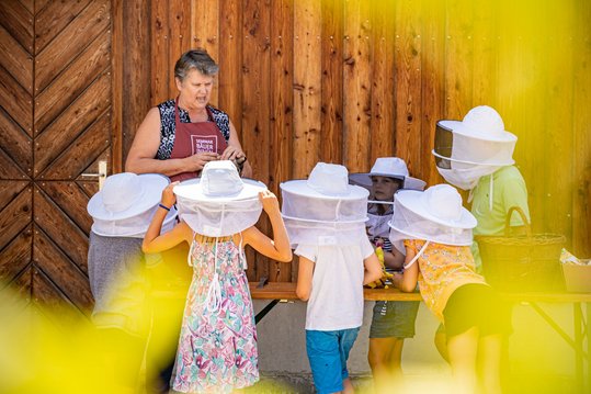 Imkereiaufgaben werden Kindern erklärt