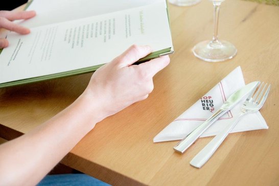 Gäste beim Lesen der Speisekarte im Top-Heurigen-Lokal
