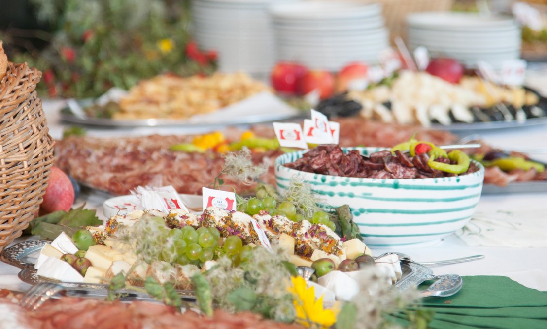 Käse- und Fleischplatten festlich angerichtet mit Streichkäse, Hartwurst, Hartkäse, Rohschinken und Obst