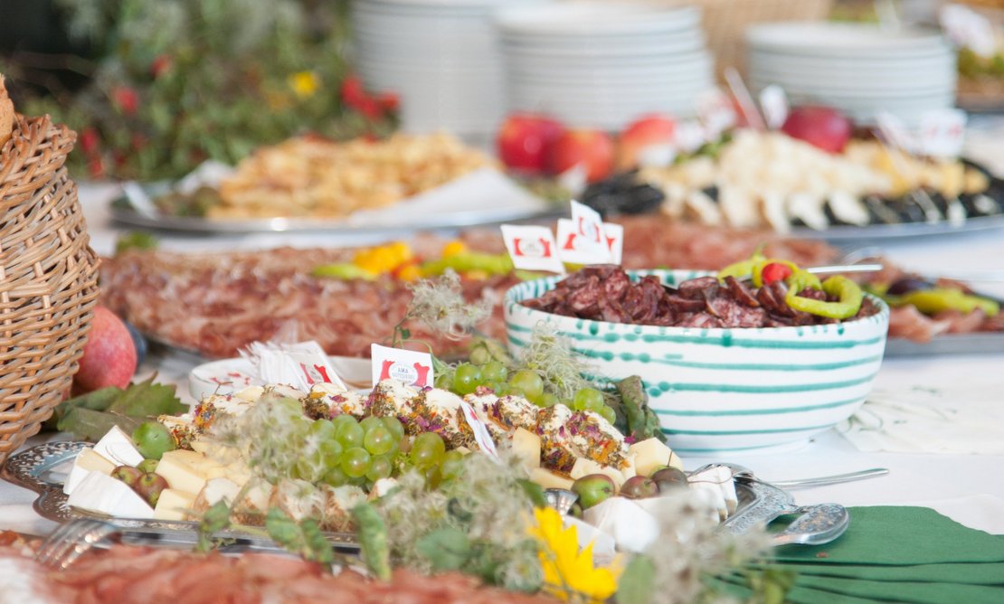 Käse- und Fleischplatten festlich angerichtet mit Streichkäse, Hartwurst, Hartkäse, Rohschinken und Obst