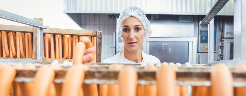 Würste auf einem Ständer warten darauf, vom Metzger geräuchert zu werden