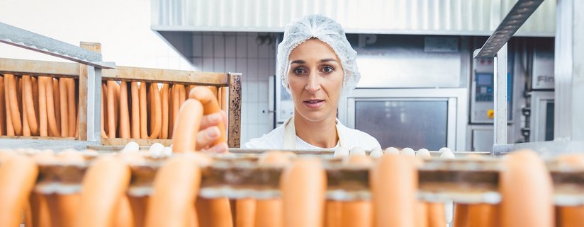 Würste auf einem Ständer warten darauf, vom Metzger geräuchert zu werden