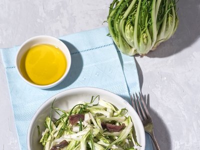 Puntarelle alla romana or asparagus Catalonian chicory salad with anchovy dressing and olive oil, italian food, selective focus, bright sunlight. Italian traditional seasoning recepies