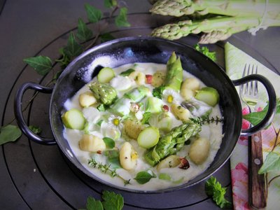Grüner Spargel in Frischkäsesoße mit Gnocchi in Pfanne angerichtet