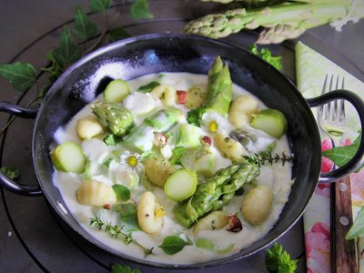 Grüner Spargel in Frischkäsesoße mit Gnocchi in Pfanne angerichtet