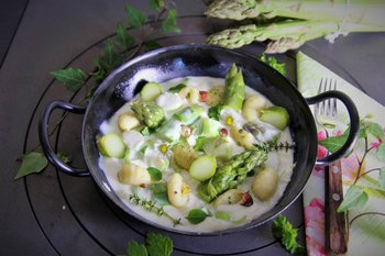 Grüner Spargel in Frischkäsesoße mit Gnocchi in Pfanne angerichtet