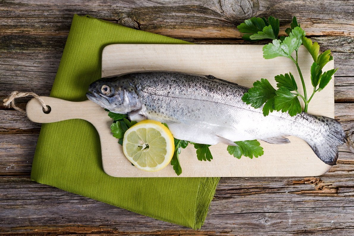 Forelle auf Holzbrett angerichtet mit Kräuter und Zitrone ©Doris Heinrichs/AdobeStock_63252325