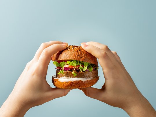 Hands holding burger. Humburger with meat free plant based cutle