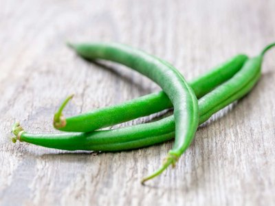 Fisolen liegen auf einem Holztisch