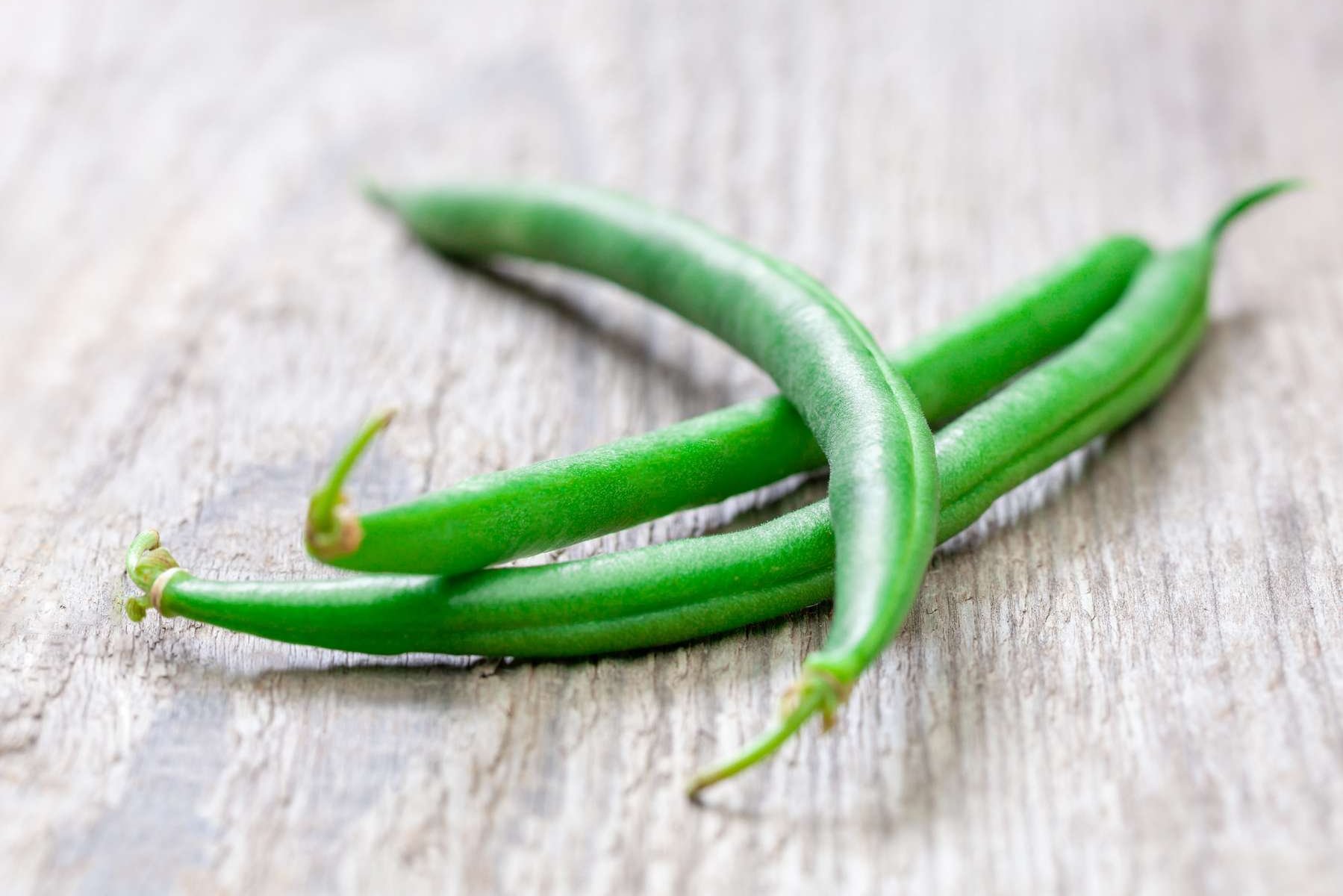 Fisolen liegen auf einem Holztisch