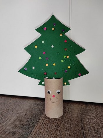 Fertiger Papier-Christbaum aus grünem Karton mit buntem Konfetti auf Klopapierrolle