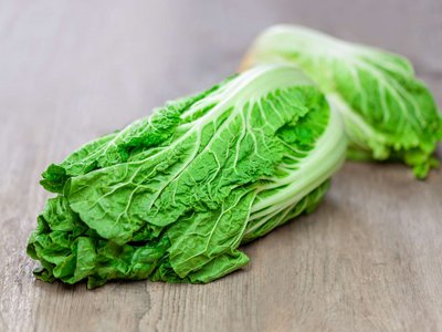 Ein Chinakohl liegt auf einem Holztisch