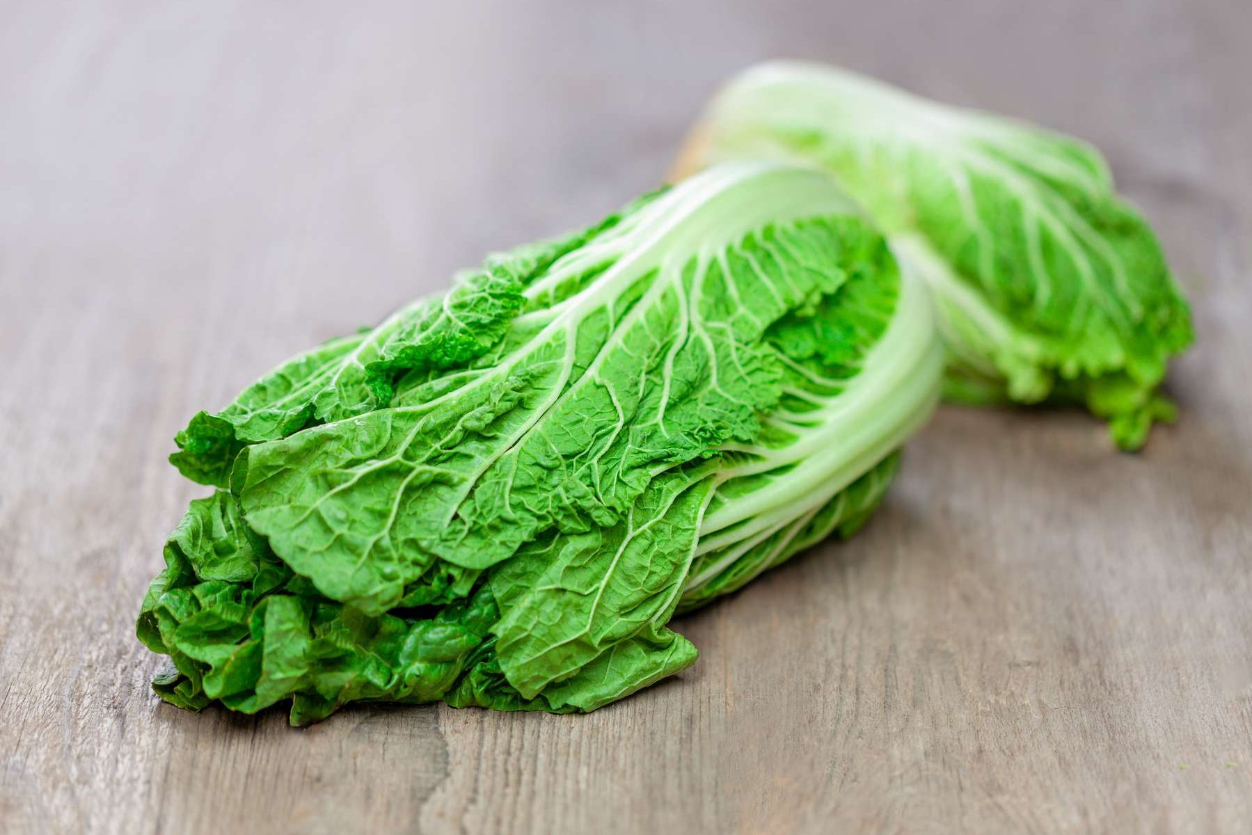 Ein Chinakohl liegt auf einem Holztisch
