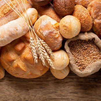 Fresh baked bread and wheat ears, top view
