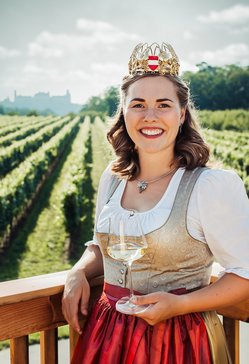 Weinkönigin Diana Müller vor Weingarten mit Weinglas