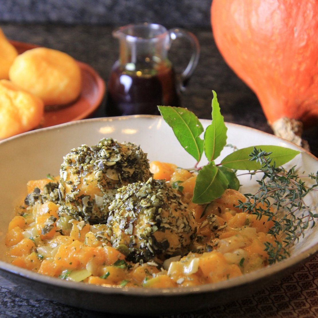Polentaklöse im Kürbiskernmantel auf Kürbisgemüse