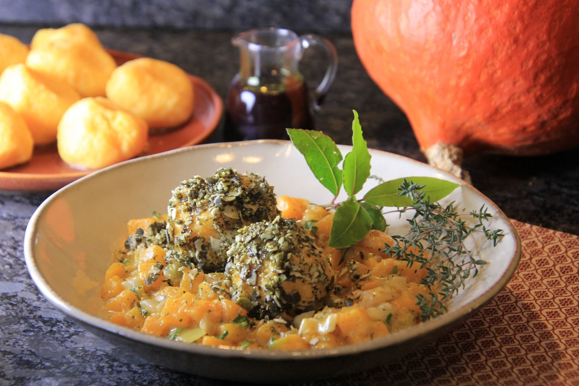Polentaklöse im Kürbiskernmantel auf Kürbisgemüse
