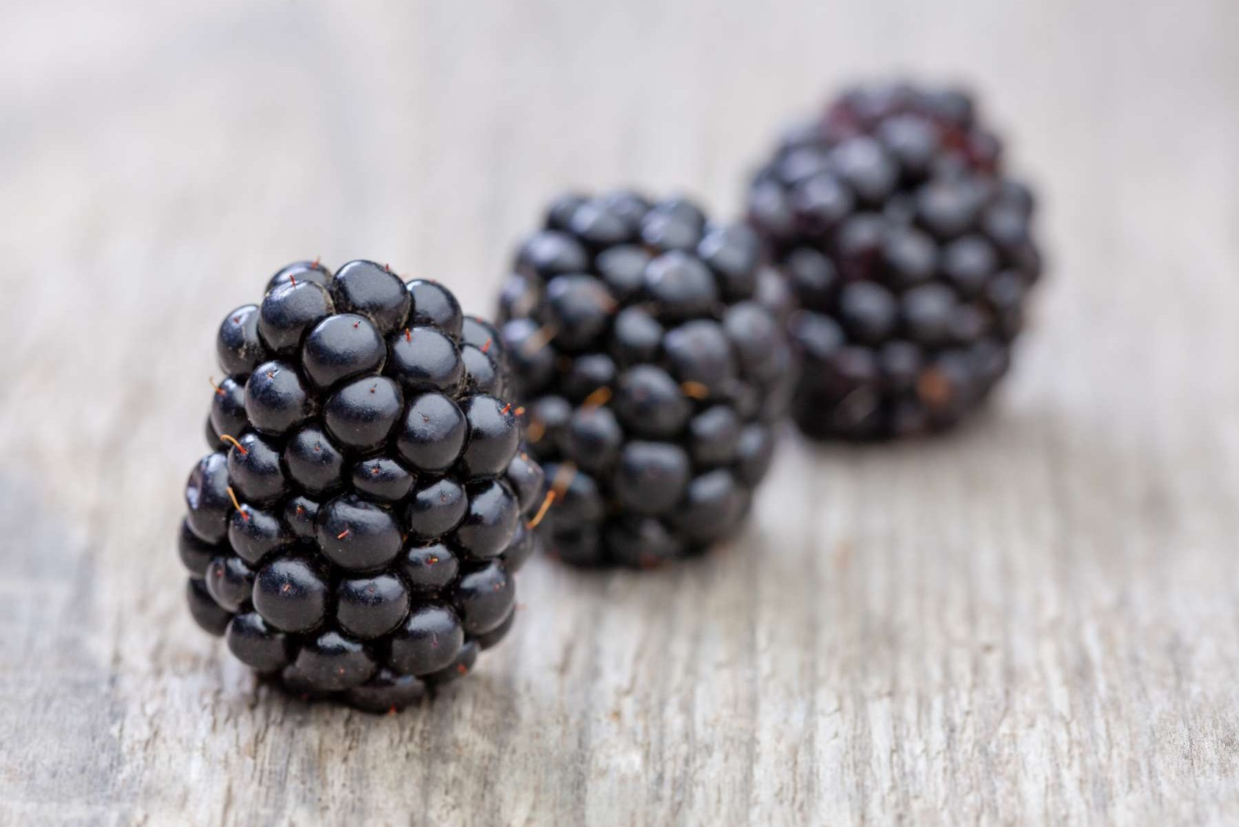 Brombeeren liegen auf einem Holztisch