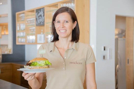 Heurigenbetreiberin Corinna Haslinger mit regionalem Heurigenburger