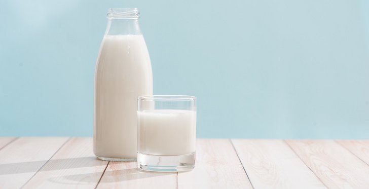 Milchflasche und Milchglas auf Holztisch ©makistock_stock_adobe_com